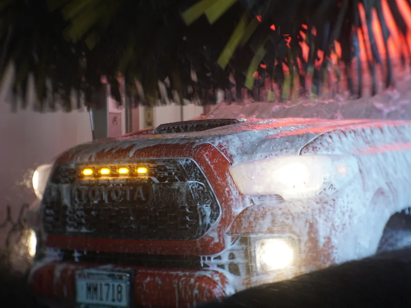 Soft-cloth mitters passing over a car inside the wash tunnel