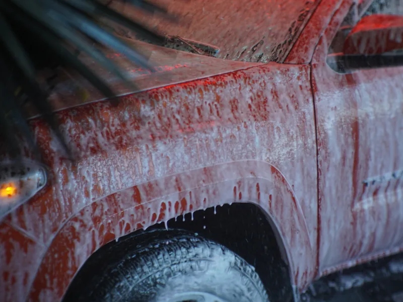 Soft-cloth mitters passing over a car inside the wash tunnel