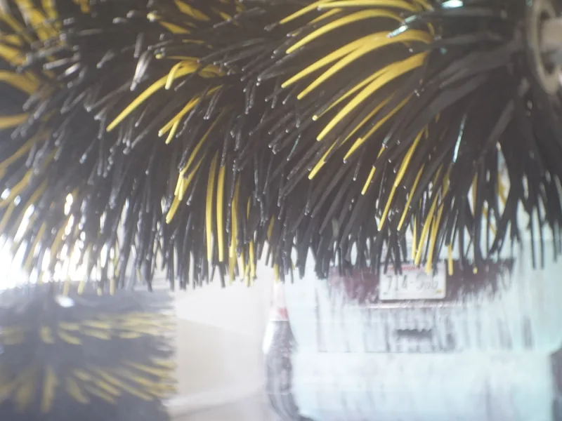 Soft-cloth mitters passing over a car inside the wash tunnel