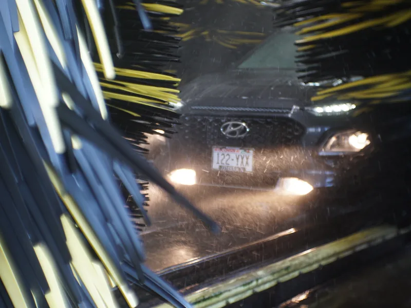 Soft-cloth mitters passing over a car inside the wash tunnel
