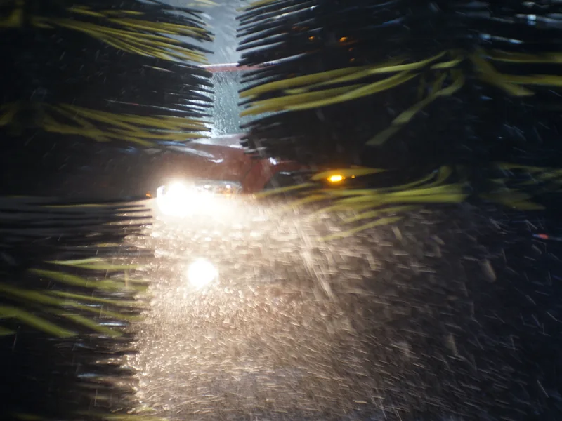 Soft-cloth mitters passing over a car inside the wash tunnel