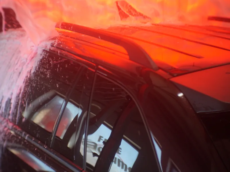 Soft-cloth mitters passing over a car inside the wash tunnel