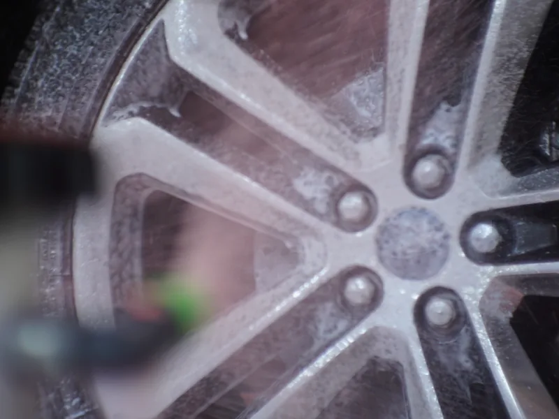 A wheel and tire being scrubbed clean in the wash tunnel