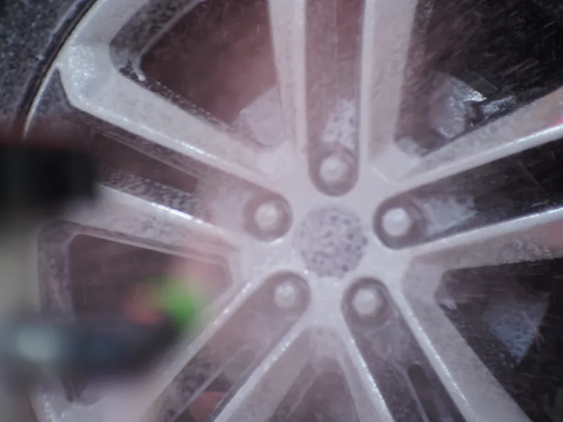 A wheel and tire being scrubbed clean in the wash tunnel