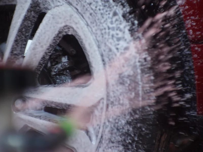 A wheel and tire being scrubbed clean in the wash tunnel