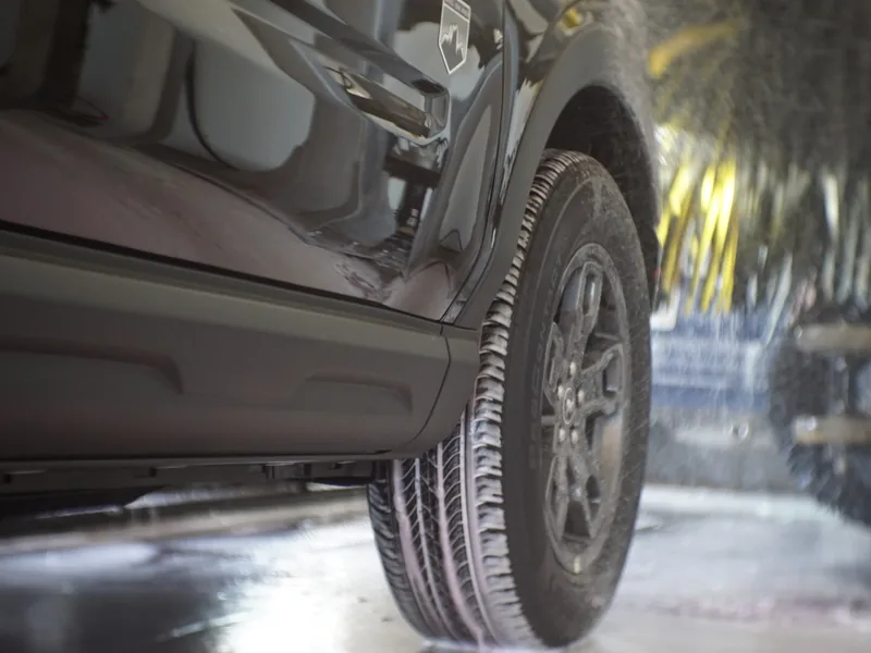 A wheel and tire being scrubbed clean in the wash tunnel