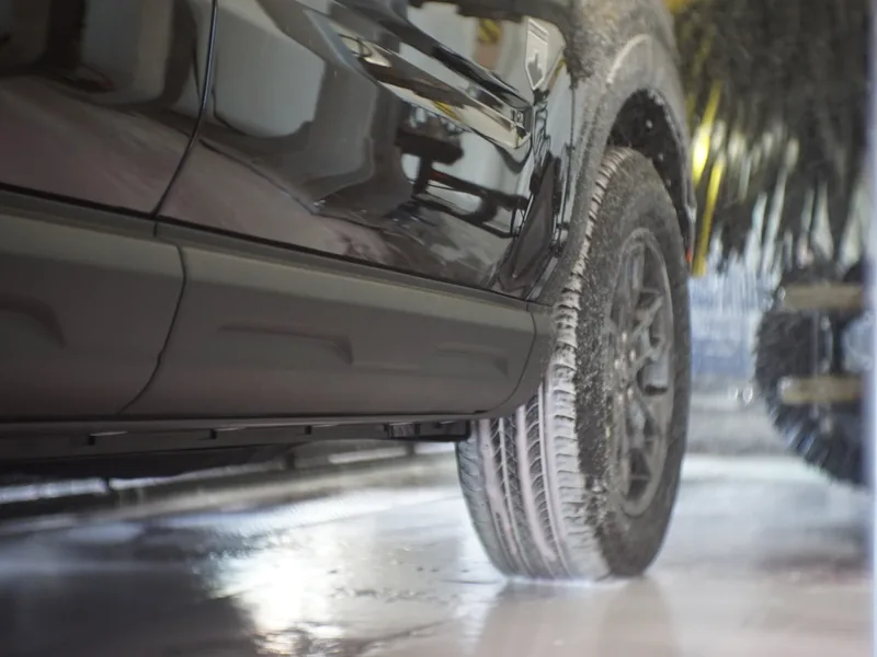 A wheel and tire being scrubbed clean in the wash tunnel