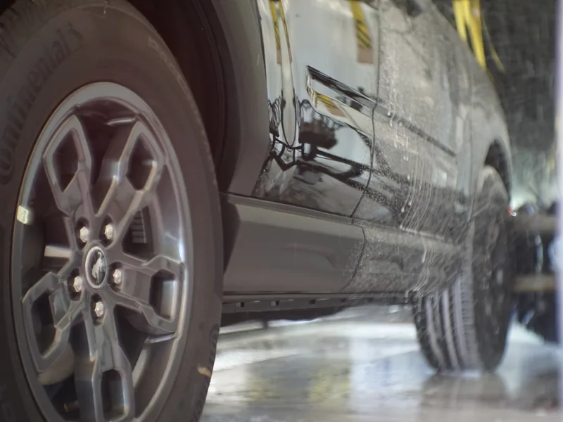A wheel and tire being scrubbed clean in the wash tunnel