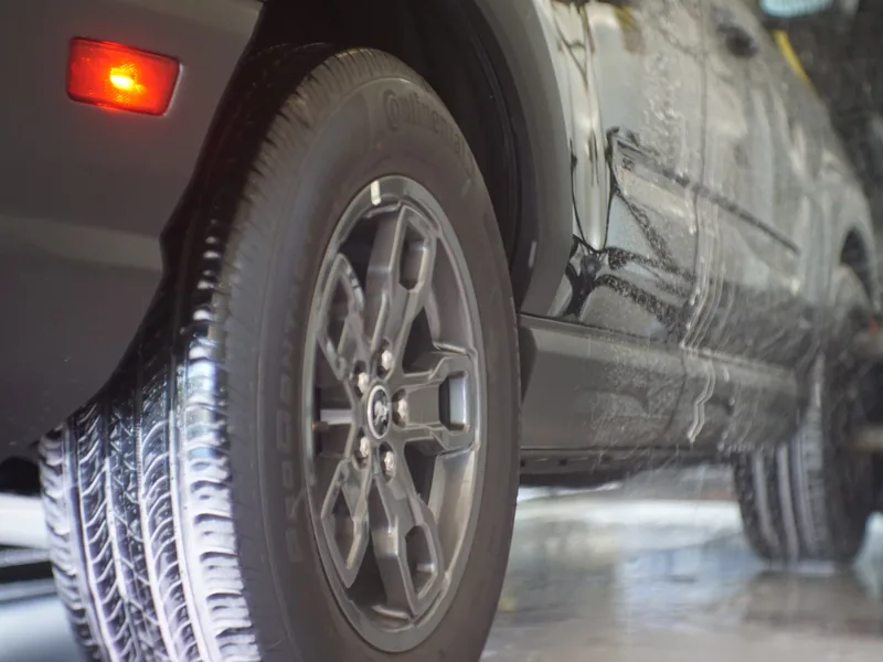 A wheel and tire being scrubbed clean in the wash tunnel