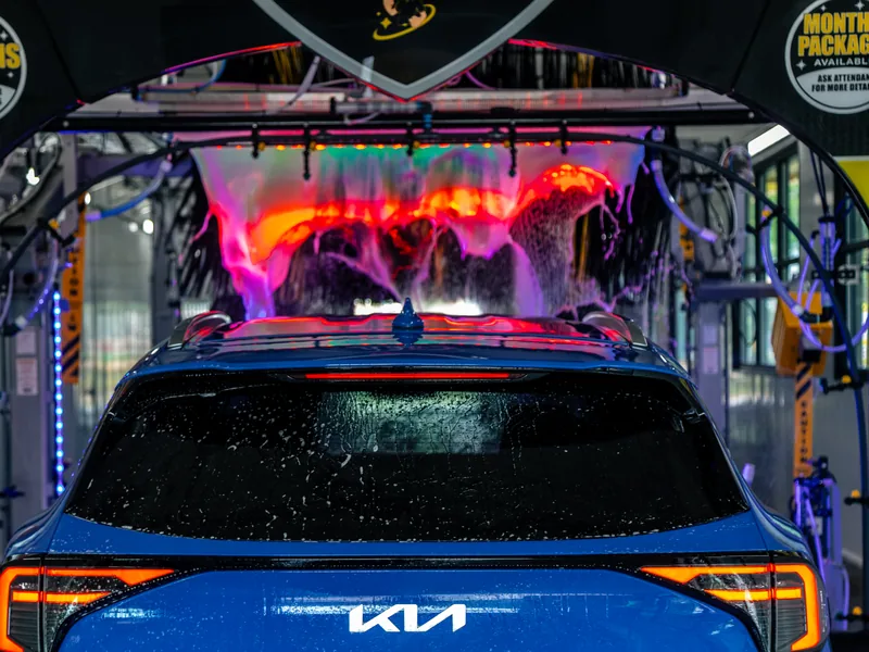 A car entering the lit wash tunnel at Mr. Splash Madison East