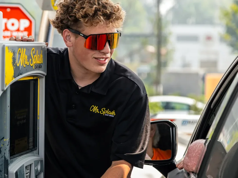 A Mr. Splash team member greeting a driver at the Madison East pay station