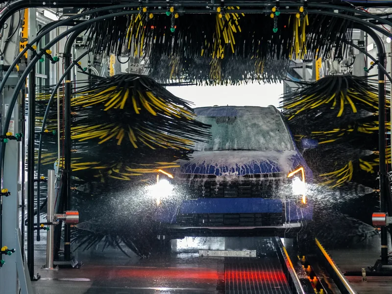 Soft-cloth mitters and high-pressure rinse inside the wash tunnel at Mr. Splash Madison East