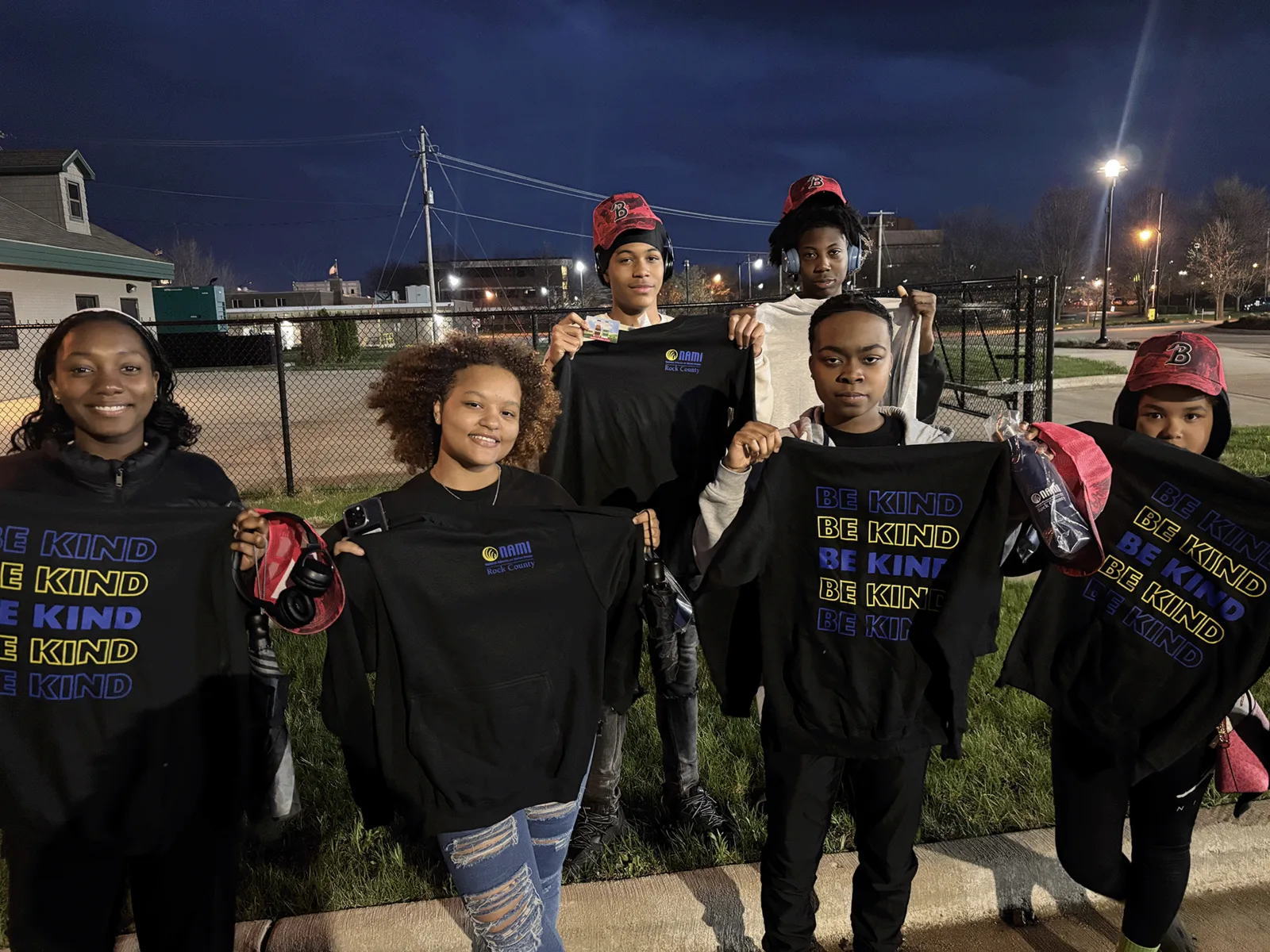 Youth group holding BE KIND shirts